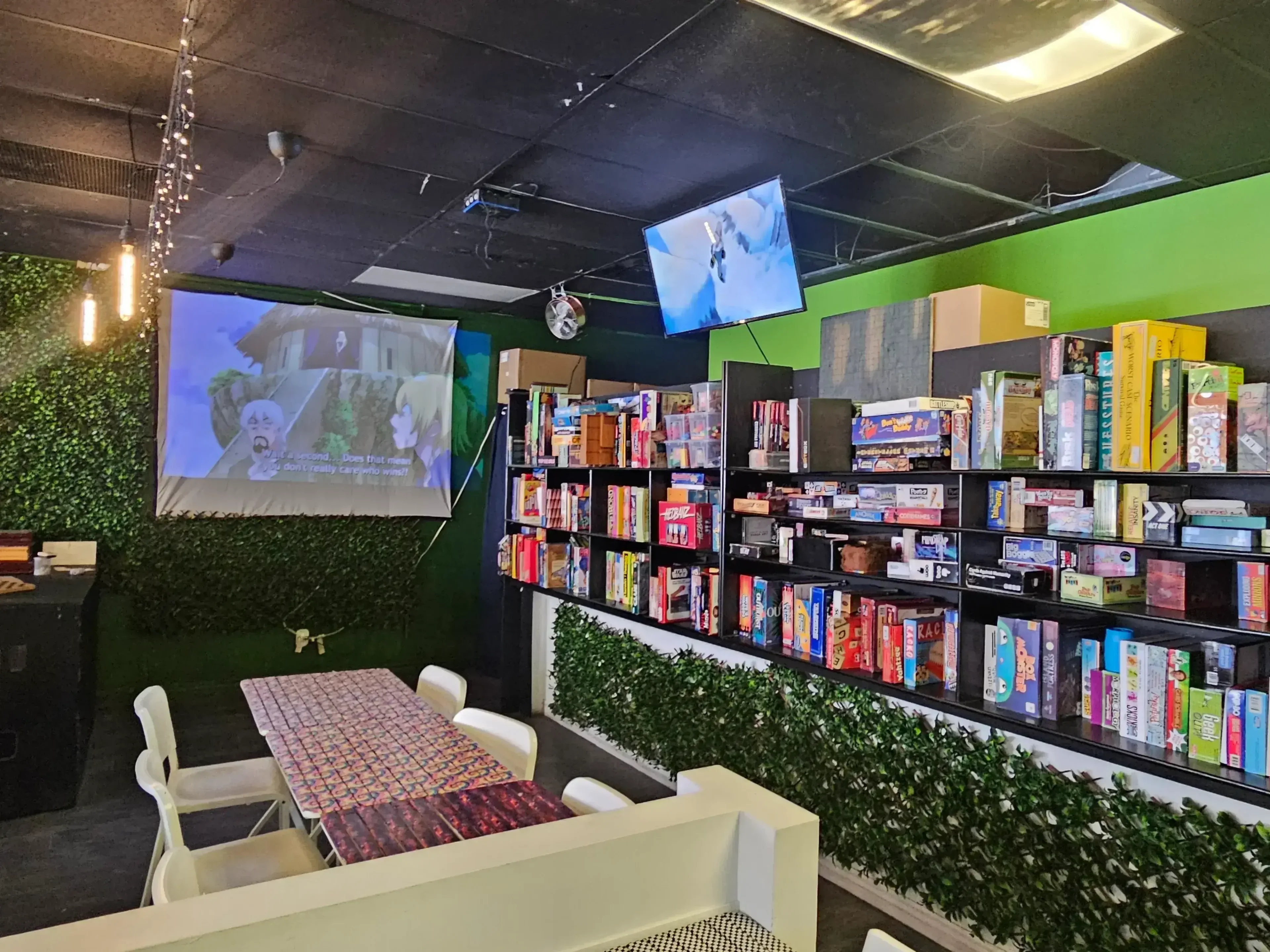 View of board games and projector playing animie at Hangout Cafe